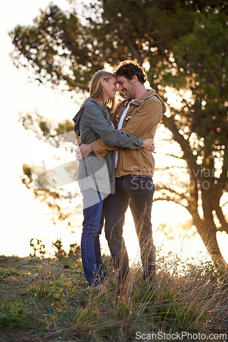 Image of Outdoor, hug and couple with love, nature and happiness with romance and bonding together in a park. People, embrace or woman with man or date with marriage or relationship with sunset or anniversary