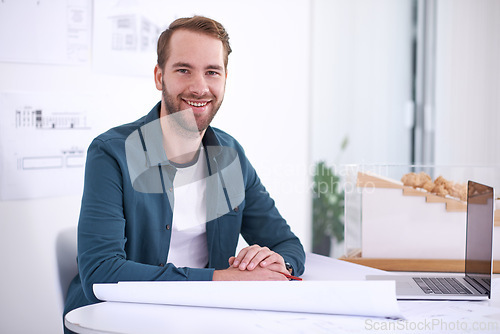 Image of Portrait, smile and blueprint with architect man in office with documents for building, design or planning. Architecture, construction and laptop with confident young developer in creative workplace