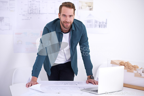Image of Portrait, laptop and layout with architect man in office with documents for building, construction or design. Architecture, construction and blueprint with confident young developer in workplace