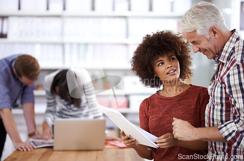 Image of Office, documents and woman talking to senior in creative workplace for project or deal for company. Colleagues, employee and staff collaboration with laptop, technology and internet in boardroom