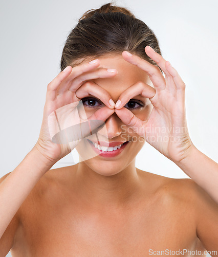 Image of Happy woman, portrait and beauty with makeup, cosmetics or skincare on a gray studio background. Face of attractive female person, brunette or model with smile and hands on face for facial treatment