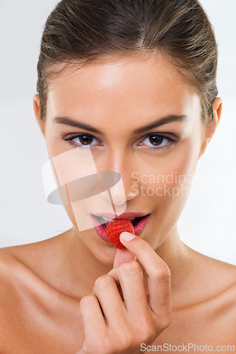 Image of Woman, portrait and raspberry for wellness in studio for health detox, healthy eating and nutrition diet. Model, person and fruit for organic cosmetics, natural beauty or skincare on white background