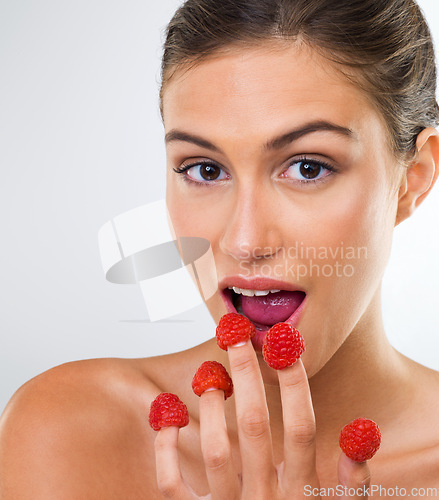 Image of Woman, portrait and raspberry with eating in studio for wellness detox, healthy body and nutrition diet. Model, person and fruit for organic cosmetics, natural beauty and skincare on white background