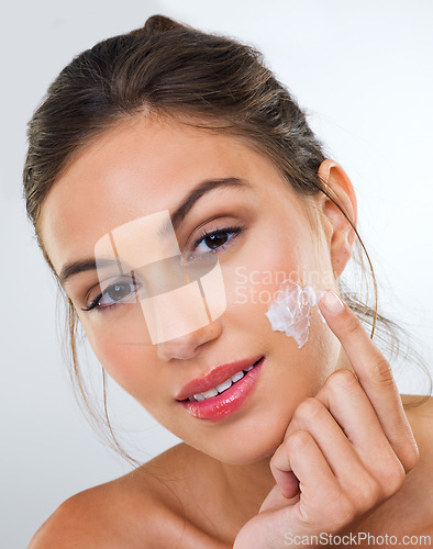 Image of Woman, cream on face and skincare for beauty, dermatology with cosmetics product or moisturizer in studio. Portrait, skin wellness with sunscreen or lotion for glow and antiaging on white background