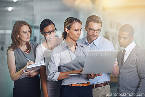 Image of Group, mentor and team collaboration with laptop helping and training employees in office. People, reading and learning from woman coaching staff in IT with advice for software or feedback on project