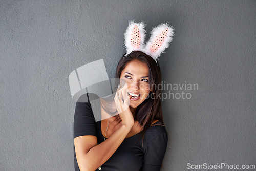 Image of Thinking, space or portrait of happy woman with bunny ears isolated on wall or grey background. Model laughing, confident or casual female person in studio with smile, funny joke or ideas on mock up