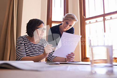 Image of Women, planning and collaboration on report in office with teamwork, support and feedback on project. People, talking and advice for paperwork, proposal and information in document for business