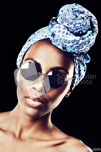 Image of Portrait, turban and culture with African woman in studio isolated on black background for heritage. Aesthetic, face and shades with confident young model in trendy headwear for traditional style