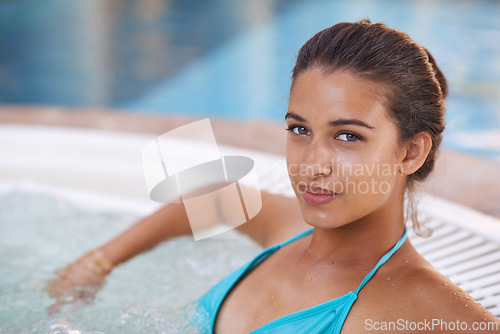 Image of Woman, portrait and smile in jacuzzi at spa for luxury vacation, summer holiday and resort on weekend. Tourist, girl and face with happiness in pool for swimming, fun getaway and wellness in bikini