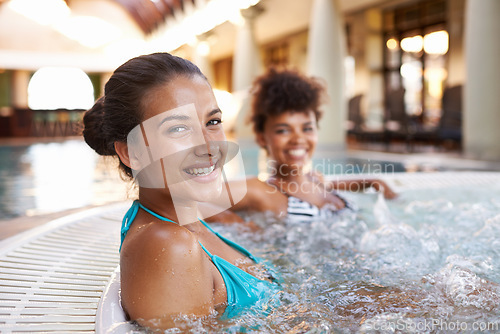 Image of Women, friends and portrait in jacuzzi to relax, self care and pamper day at spa for wellness and healing. Water, bubbles and happy in hot tub for detox and stress relief, friendship date and bonding