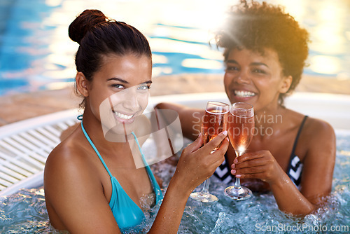 Image of Women, friends and wine in jacuzzi in portrait, self care and pamper day at spa for wellness and cold beverage. Water, bubbles and alcohol drink in hot tub for detox and friendship date for bonding