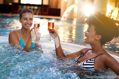 Image of Happy woman, friends and relax with drinks in jacuzzi at hotel, resort or hot tub spa together. Face of female person or people smile with glass of champagne for relaxation, hospitality or vacation