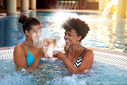 Image of Women, friends and happy in jacuzzi with Champagne, self care and pamper day for wellness and cold beverage. Water, bubbles and alcohol drink in hot tub for detox, friendship date cheers and bonding