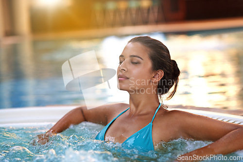 Image of Woman, face and relax in jacuzzi at spa for luxury vacation, summer holiday and resort on weekend. Tourist, girl and sun tan with confidence in pool for swimming, fun getaway and wellness in bikini