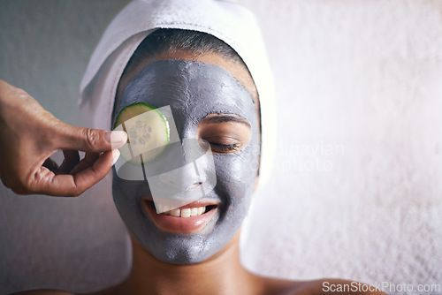 Image of Woman, face mask and smile with hands and cucumber for facial, spa wellness and beauty treatment. Above, towel and calm female person with skincare and relax at hotel with glow and cosmetic cream