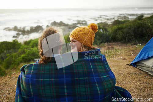 Image of Blanket, love and couple camping in nature for vacation, adventure or holiday together. Happy, conversation and young man and woman talking, bonding and relaxing by ocean on romantic weekend trip.