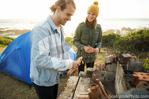 Image of Nature, happy and couple with fire for camping on romantic vacation, adventure or holiday. Smile, love and young man and woman with flame for warm on outdoor winter weekend trip with tent together.