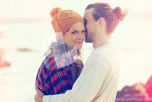 Image of Beach, smile and portrait of couple hugging with love on vacation, adventure or holiday together. Happy, love and young man and woman embracing with care by ocean or sea on weekend trip in winter.