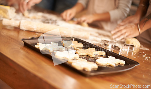 Image of Bake, gingerbread man biscuits and people in kitchen of home, closeup for cooking or pastry preparation. Food, baking or cookies with hands of family at wooden counter in apartment for snack recipe