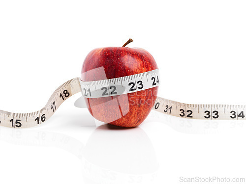 Image of Apple, wellness and tape measure with red fruit in studio isolated on white background for diet, health or nutrition. Sustainability, vitamins and size with organic produce for detox or weightloss