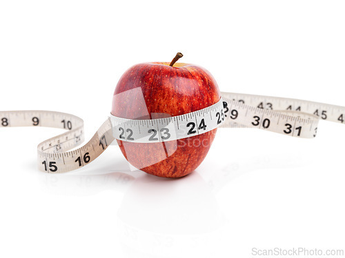 Image of Apple, wellness and measuring tape with red fruit in studio isolated on white background for diet, health or nutrition. Sustainability, size and minerals with organic produce for detox or weightloss