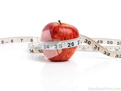 Image of Apple, food and tape measure with red fruit in studio isolated on white background for diet, health or nutrition. Size, vitamins and minerals with organic produce for wellness, detox or weightloss