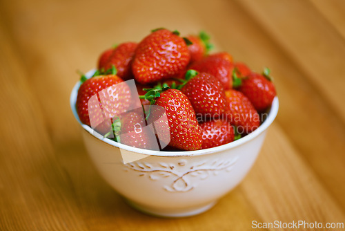 Image of Strawberries, bowl and counter for health, wellness or organic diet on wood countertop. Fruit, nutrition or produce for eating, gourmet and meal or cuisine with vitamins or fresh for weight loss