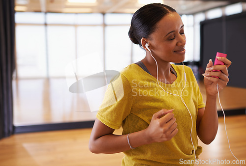 Image of Music, girl and dancer listening with earphones connect on digital device in studio or gym in weekend. Audio, female person and woman streaming songs on app to relax with technology and sound