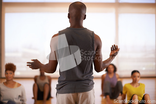 Image of People, dancer and instructor with class of students in fitness, workout or pilates at the studio. Rear view of personal trainer talking to group in body warm up or stretching for health and wellness