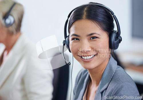 Image of Help desk, portrait and phone call with Asian woman, headset and consultant at customer support office. Mic, telemarketing and client service agent at callcenter with happy, friendly face and smile