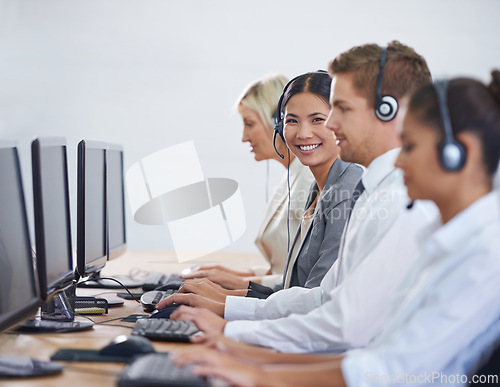 Image of Help desk, phone call and portrait of woman in row typing on computer at customer support. Headset, telemarketing and client service agent at callcenter for consultation, teamwork and smile in office