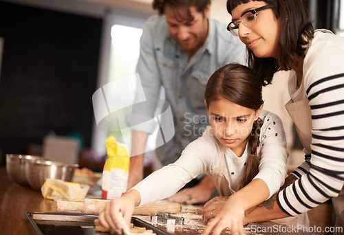 Image of Mother, father and girl with baking cookies in kitchen with pan, happiness and teaching with support. Family, parents and child with helping, learning and bonding with cooking for dinner and snack