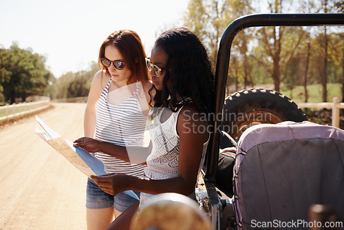 Image of Women, reading and map on roadtrip in nature, direction and travel adventure with care in outdoor. Friends, lost or navigation with van on summer holiday, rest or bonding together for trip in texas