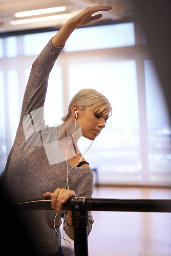 Image of Earphone, ballet and woman with body stretch in dance studio for performance, show or theater rehearsal. Art, balance or dancer with stretching pole for ballroom, fitness or warm up stage training