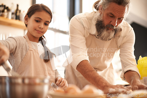 Image of Girl, child and grandfather with baking in kitchen for cooking, cookies and teaching with support or helping. Family, senior man and grandchild with dough preparation in home for bonding and learning