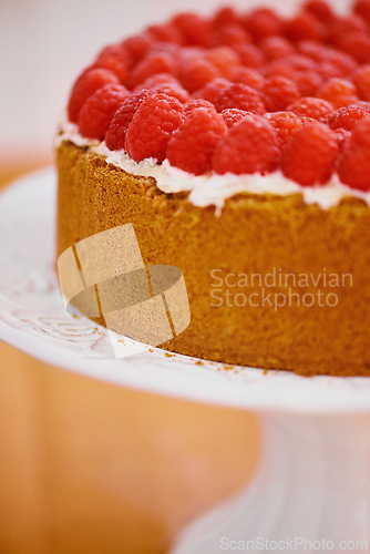 Image of Plate, cream and cheesecake with raspberries on table for sweet snack for tea time at home. Bakery, catering and closeup of gourmet dessert with crust, frosting and fresh organic fruit in dining room