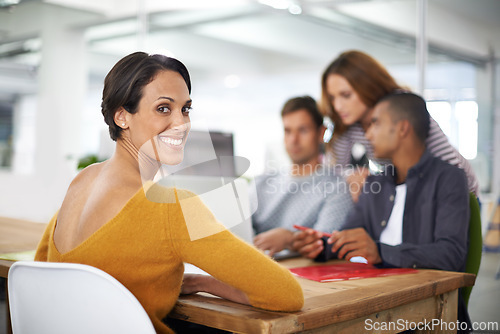 Image of Woman, portrait and smile at desk with meeting for business or creative company, planning and teamwork. Female person or designer, office and collaboration for startup agency, laptop and online work.