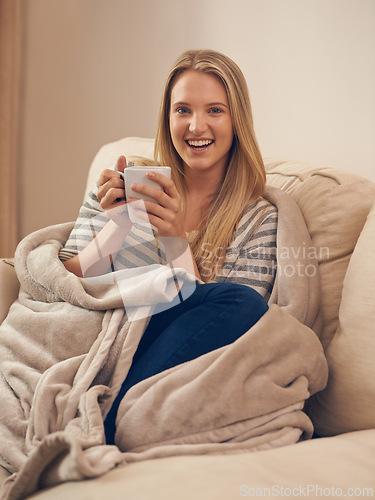 Image of Happy, portrait and woman on a sofa with coffee break, relax or chilling on weekend in her home. Face, smile and female person in a living room with tea cup for resting, peaceful or me time in house