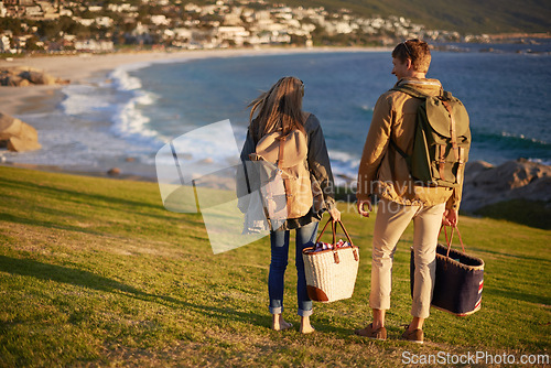 Image of Love, walking and couple on hike with ocean, sunset for tropical holiday adventure, relax and bonding together. Picnic, man and woman on romantic date on beach, nature and grass on vacation from back