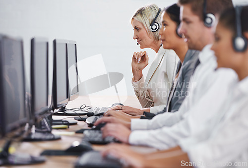 Image of Help desk, phone call and row of women, men and typing on computer at customer support. Headset, telemarketing and client service agent at callcenter for online consultation, team and business people