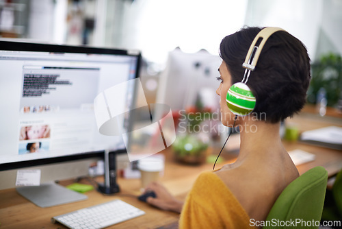 Image of Business, designer and woman with headphones at computer screen in office for creative internship and web design. Employee, rear view and monitor for multimedia production and video animation at desk