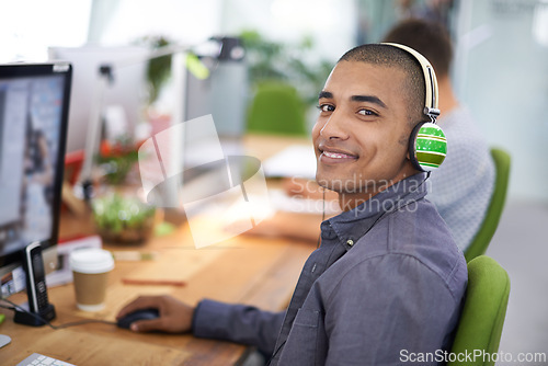Image of Business, designer and portrait of man with headphones in office on computer for creative internship and web design. Employee, face and happiness for multimedia production, website or video at desk