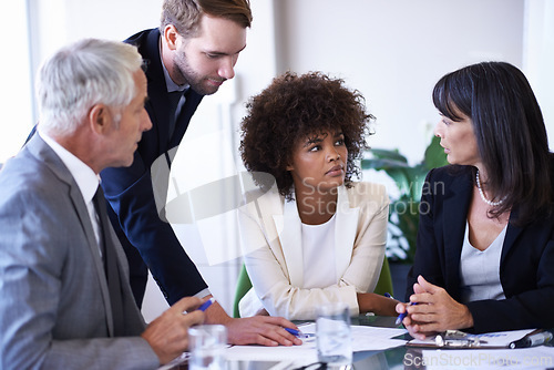 Image of Business people, teamwork and meeting with brainstorming in office for financial review, documents and diversity. Professional, employees and collaboration in boardroom with feedback or communication