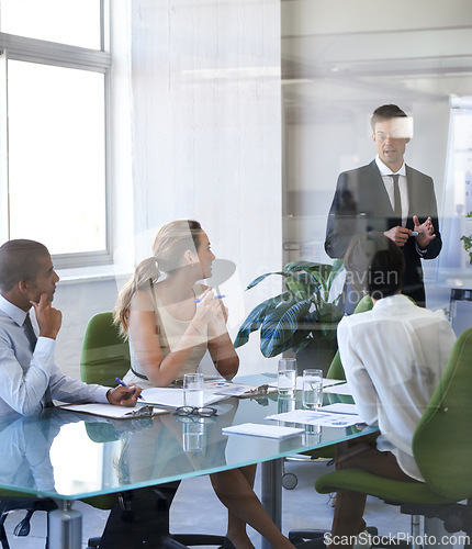 Image of Meeting, presentation and businessman in office with reflection, stats or speaker at b2b workshop. Teamwork, discussion and business people in conference room brainstorming ideas, planning and review