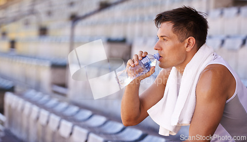 Image of Stadium, relax man or athlete for drinking water and commitment to fitness for sprinting competition. Person, competitive and runner with thinking in sport, planning and health drink for performance