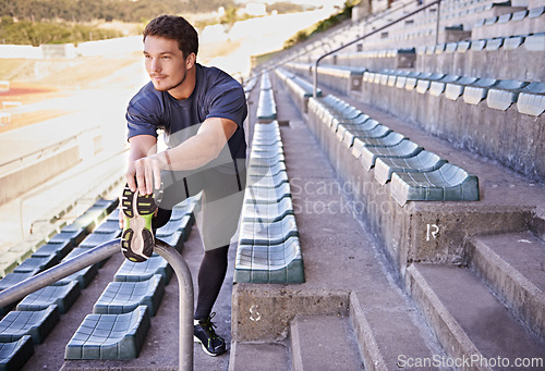 Image of Sports, legs and man stretching in stadium for race, marathon or competition training for health. Fitness, wellness and male runner athlete with warm up exercise for running cardio workout on track.