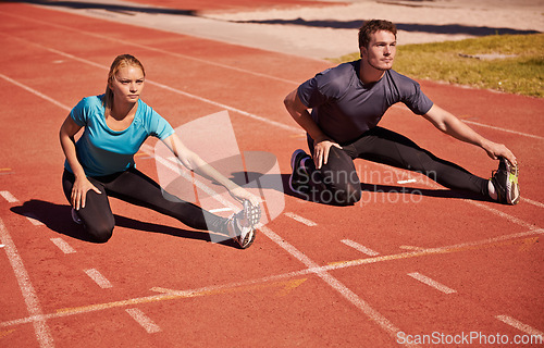 Image of Training, legs and couple stretching in stadium for race, marathon or competition for health. Sports, fitness and runner athletes with warm up exercise for running cardio workout on outdoor track.