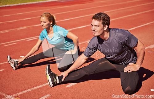 Image of Workout, legs and couple stretching in stadium for race, marathon or competition training for health. Sports, energy and runner athletes with warm up exercise for running cardio on outdoor track.