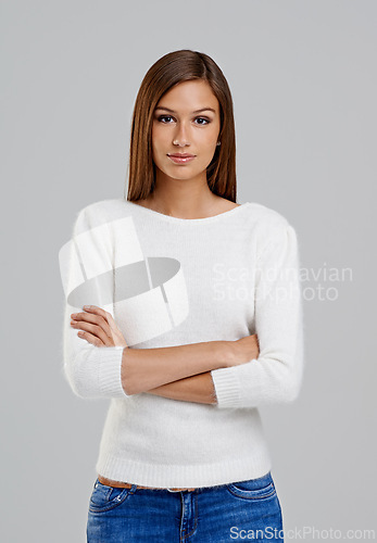 Image of Portrait, arms crossed and woman in studio for fashion isolated on a white background. Confidence, young person and serious model in casual clothes, jeans or trendy style on backdrop in Argentina