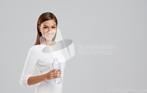 Image of Portrait, happy woman and drinking water in studio isolated on a white background mockup space for wellness. Face, bottle and person with liquid for hydration, nutrition and healthy diet for body